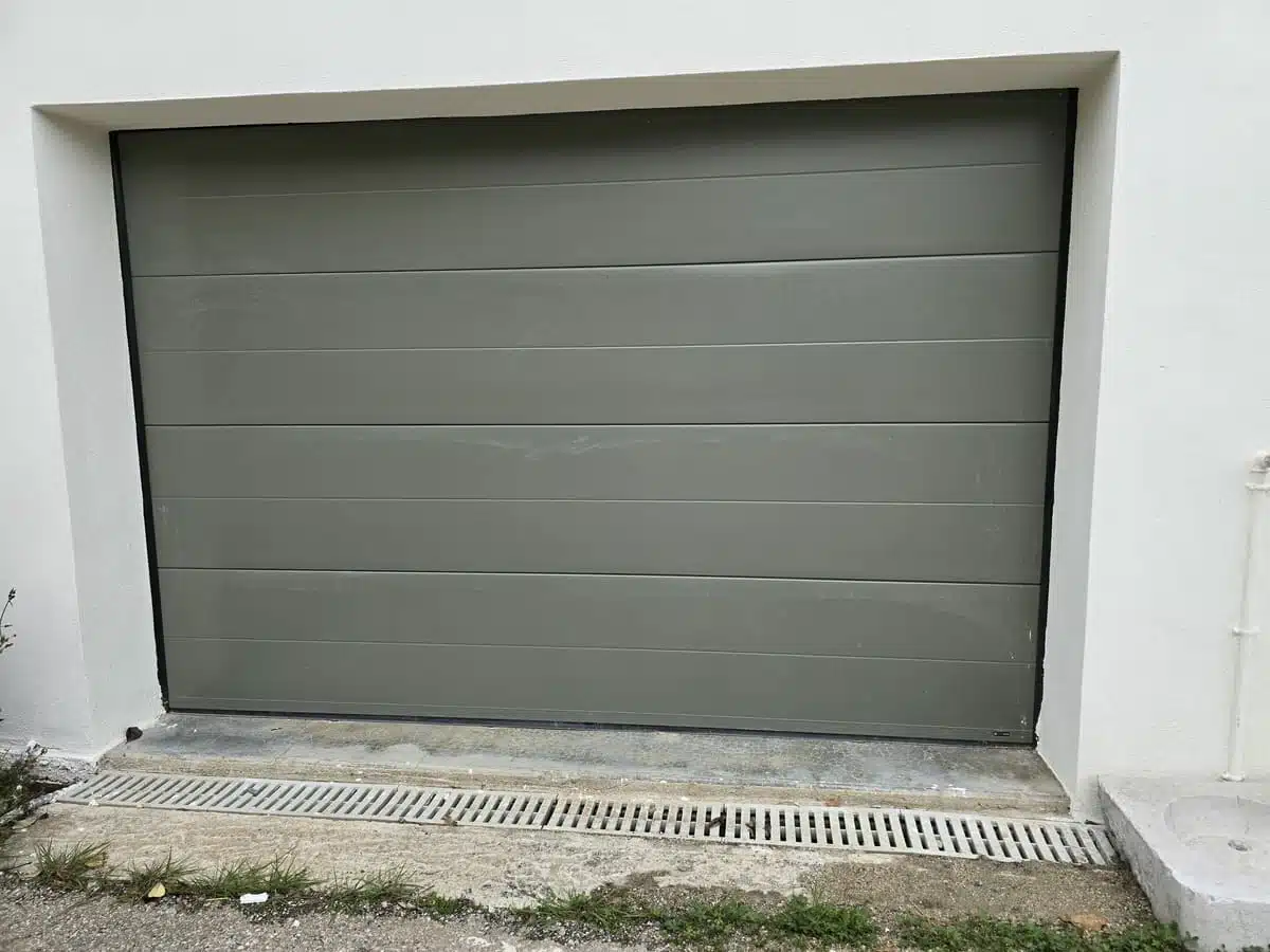 Porte de garage sectionnelle motorisée RAL 7003 à Tourrettes-sur-Loup, au design lisse avec mono rainure, offrant esthétisme moderne et confort d’utilisation.