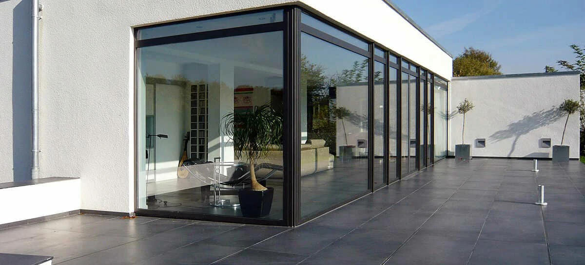 Châssis aluminium FINSTRAL noir sablé avec grandes baies vitrées pour maison moderne.
