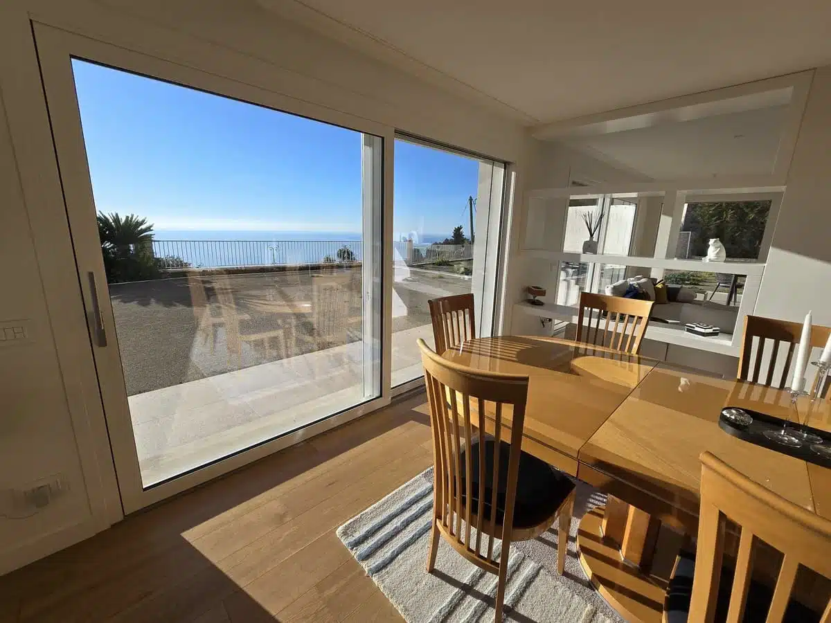 Baie coulissante à levage en PVC de la marque Finstral installée à Èze, offrant une vue panoramique sur la mer. Une menuiserie élégante et performante alliant isolation, esthétisme et confort d’utilisation.