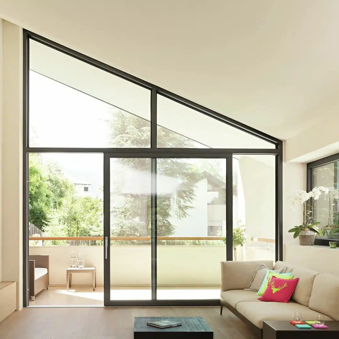 Baie vitrée coulissante à levage Finstral en aluminium avec imposte fixe trapézoïdale, installée à Valberg pour un intérieur lumineux et design