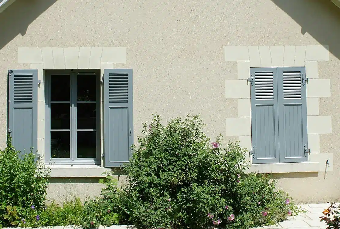 Volets battants en aluminium EHRET avec persiennes à lames américaines installés sur maison traditionnelle à Vence, alliant élégance provençale et durabilité