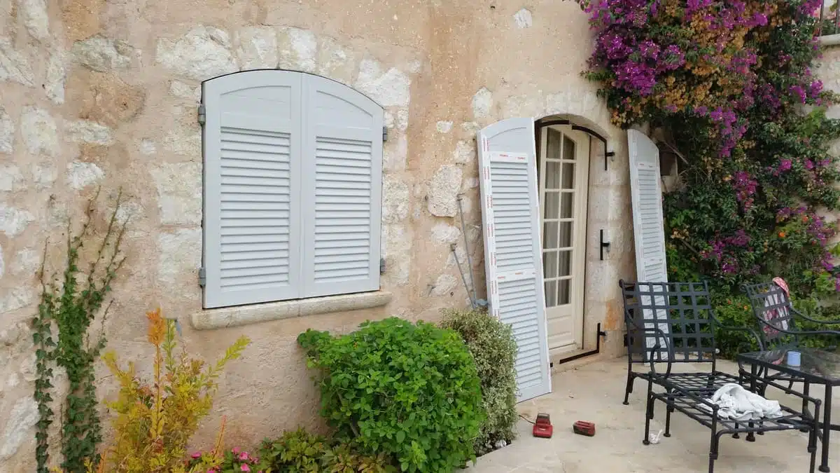 Volets battants PVC FINSTRAL cintrés avec persienne et panneaux pleins installés à Saint-Paul-de-Vence.